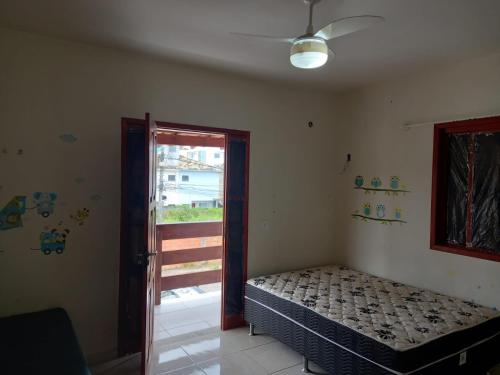 里约达欧特拉斯Casa em Costa Azul的一间卧室设有一张床,并有通往阳台的门