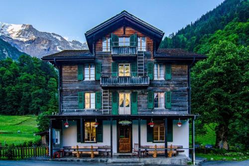 施特歇尔贝格Alpenhof Mountain Lodge的前面设有长椅的大型木制房屋