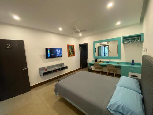 SabogaHOSTAL LOS CEDROS的一间卧室配有一张床、一张书桌和一台电视