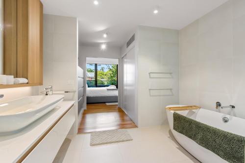 墨尔本Fantastic 3-Bed Home by Melbourne Uni & Zoo的白色的浴室设有浴缸和水槽。