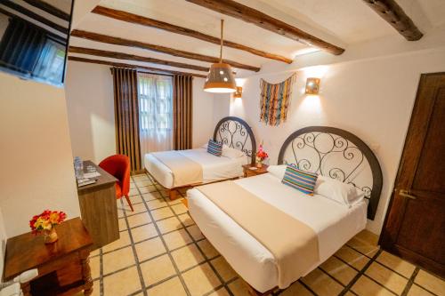 马丘比丘Vilas Insight Hotel Machupicchu的酒店客房设有两张床和一张桌子。