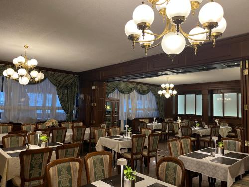 皮耶什佳尼GRAND HOTEL SERGIJO RESIDENCE superior Adult only luxury boutique hotel的用餐室配有桌椅和吊灯。
