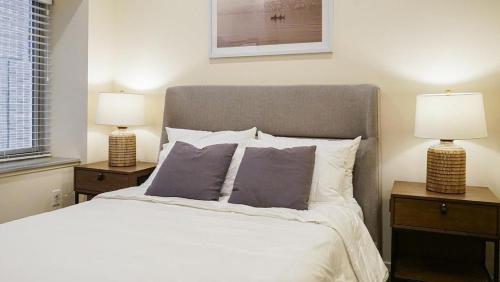奥马哈Landing Modern Apartment with Amazing Amenities (ID8398X48)的一间卧室配有一张带两张台灯的床铺。