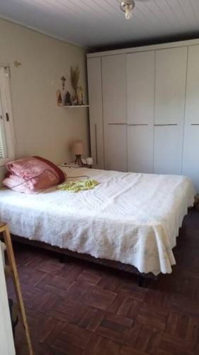 卡庞达卡诺阿Casa - ótima localização的一间卧室配有一张带白色橱柜的大床