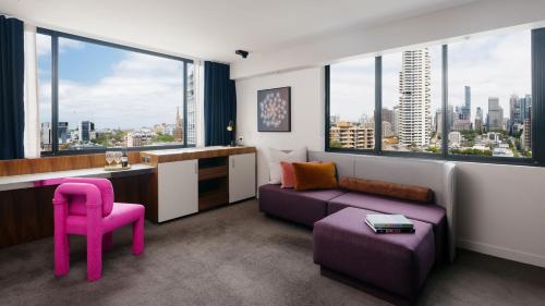 悉尼悉尼蓝塞瑞拉莫特酒店的客厅配有紫色沙发和粉红色椅子
