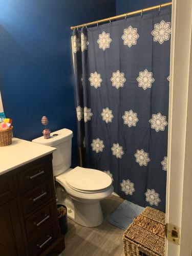 ConleyHappy Place的浴室设有卫生间和蓝色的浴帘。