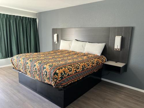 阿卡德尔菲亚Pioneer INN的一间卧室配有一张大床和色彩缤纷的毯子