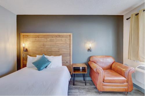 棕榈泉The Infusion Beach Club的配有一张床和一把椅子的酒店客房