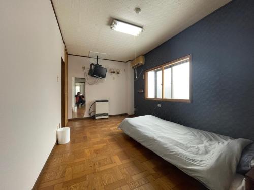 新潟県小千谷市 平成イン的一间卧室设有一张床和蓝色的墙壁