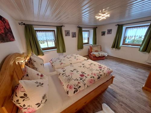 贝希特斯加登Ferienwohnungen Kilianmühle的一间卧室,卧室内配有一张床和一把椅子