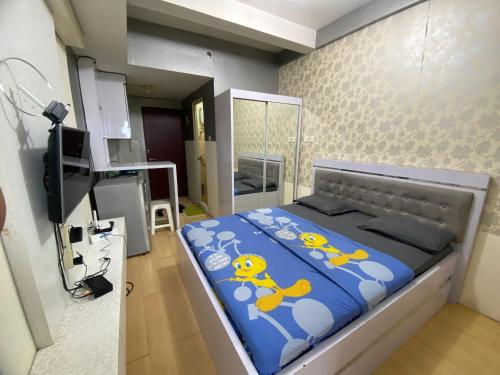 万隆RedLiving Apartemen Tamansari Panoramic - Anwar Rental的一间卧室配有一张带蓝色棉被的大床