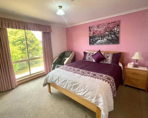 金斯顿Oscars Retreat的一间卧室设有紫色的床和窗户