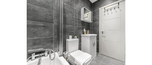 特威克纳姆City Elegance: Spacious 2BR for Urban Comfort的一间带卫生间和浴缸的浴室