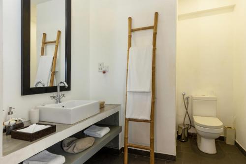 本托塔The Villa Bentota by KK Collection的一间带水槽、卫生间和镜子的浴室