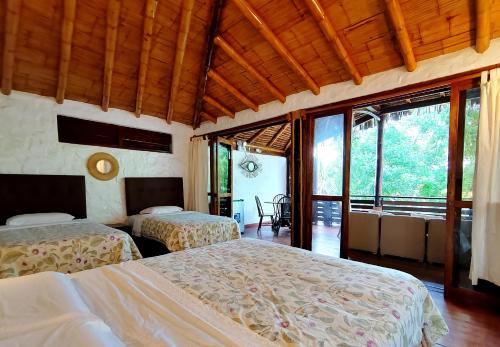 洛斯拉甘斯El Mirador de Punta Veleros的一间带两张床的卧室,位于带窗户的房间内
