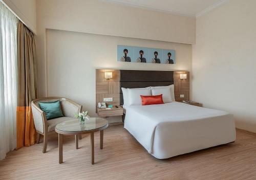维沙卡帕特南Greenpark Visakhapatnam的酒店客房配有白色的床和桌子