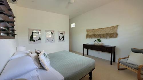 维拉港Longview - stunning views, sleeps 7的卧室配有1张床、1张桌子和1把椅子