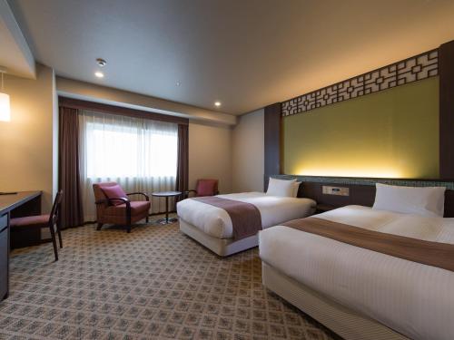 长崎JR长崎九州酒店的酒店客房配有两张床和一张书桌