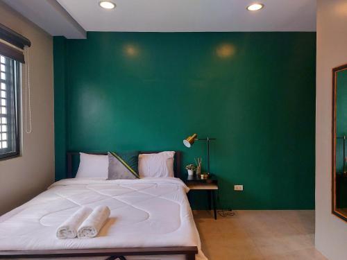 美岸Minimalist Vigan Condo Near Calle Crisologo的一间卧室设有一张大床和绿色的墙壁