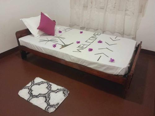 希克杜沃Laliz的一张铺有白色床单和紫色花卉的床