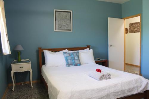 拉罗汤加Rutaki Retreat的一间卧室配有一张蓝色墙壁的床