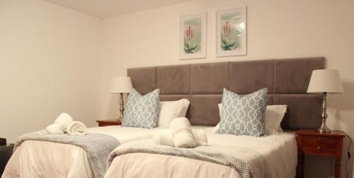 马普托Ka maxakeni guesthouse的一间卧室配有两张带白色和蓝色枕头的床