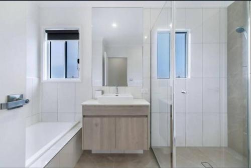 黄金海岸Townhouse in Hope Island的白色的浴室设有水槽和淋浴。