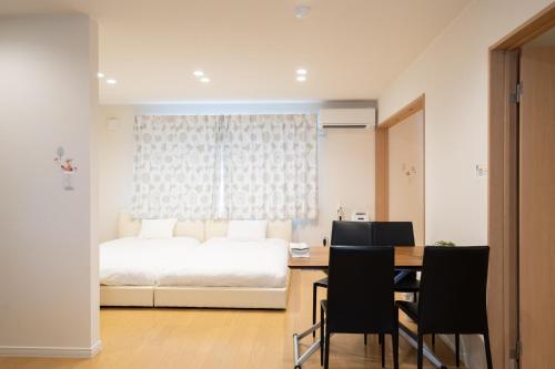 东川町The Peak Villa Suite Hokkaido的卧室配有一张床和一张桌子及椅子