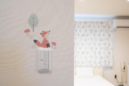 东川町The Peak Villa Suite Hokkaido的墙上有两个狐狸标记的灯开关