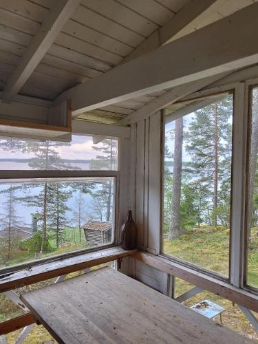 HoutskariTopsala Seaside的客房设有2扇窗户和1张木桌。