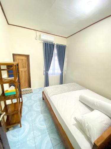 纳闽巴霍Cendana Guesthouse Labuan Bajo2的卧室配有床、椅子和窗户。