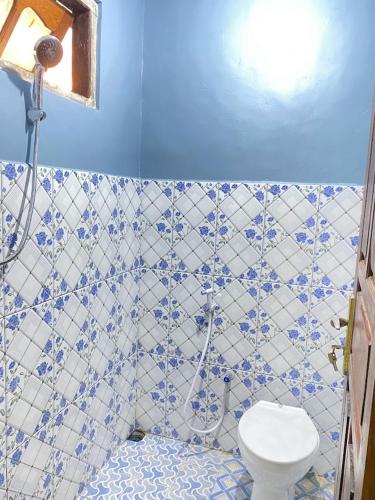纳闽巴霍Cendana Guesthouse Labuan Bajo2的蓝色和白色的浴室设有卫生间