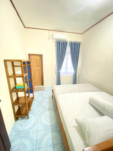 纳闽巴霍Cendana Guesthouse Labuan Bajo2的一间卧室设有一张床和梯子