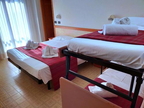 里米尼Ben Hur Rimini的酒店客房,配有两张床和椅子