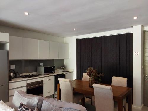 乌姆兰加Dolce vita luxurious apartment的厨房以及带桌椅的用餐室。