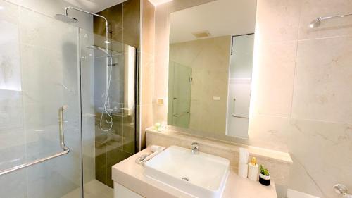 清迈The Astra Chaing Mai的一间带水槽和玻璃淋浴的浴室