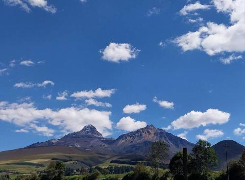 ChaupiCasa Andina Los Ilinizas的享有蓝天和云的山景