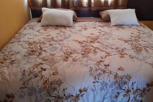 ChaupiCasa Andina Los Ilinizas的一张带花卉床罩和枕头的床