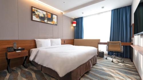 全州市Gloucester Hotel Jeonju的配有一张床和一张书桌的酒店客房