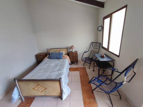 苏克雷Acogedora, independiente y tradicional Casa - Karapanza的卧室配有一张床和一张桌子及椅子