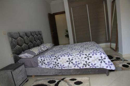 拉巴特Mahaj的一间卧室配有一张带紫色和白色棉被的床