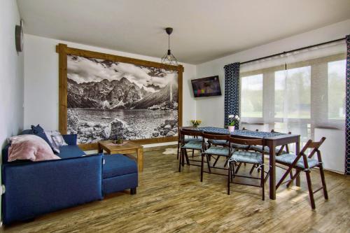 斯扎法拉瑞Domki Magia Gór-nocleg obok Term的客厅配有餐桌和蓝色沙发