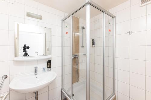 萨尔茨堡辛德布尔旅馆的带淋浴和盥洗盆的白色浴室