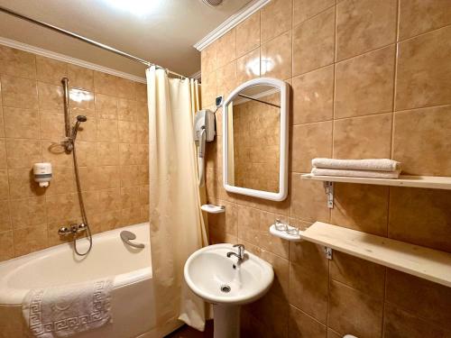 阿达兹Čill Easy hotel with self check-in的浴室配有盥洗盆、浴缸和镜子