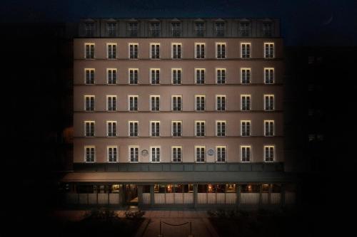 巴黎Maison Proust, Hotel & Spa La Mer的一座高大的建筑,晚上有灯