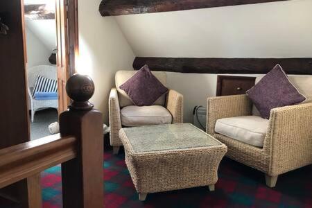 斯泰兹LetAway - Captain Cook's Cottage, Staithes的客厅配有两把椅子和一张桌子