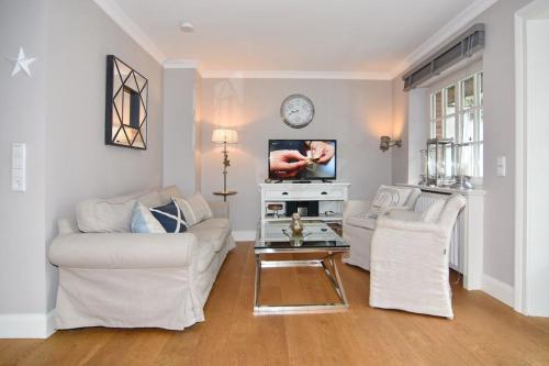 提努姆Gartenweg 9, Whg Oland的客厅配有2张白色沙发和电视