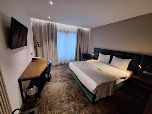萨格勒布iNova的配有一张床和一张书桌的酒店客房