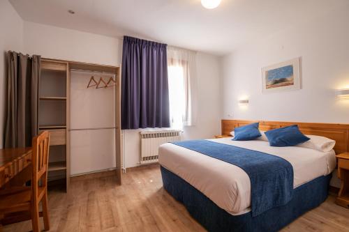 塔瓦斯坎马尔克桑特酒店的一间卧室配有一张床、一张书桌和一个窗户。