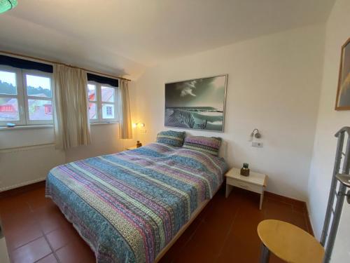 德兰斯克Gemütliches Apartment in Strandnähe的卧室配有床、桌子和窗户。
